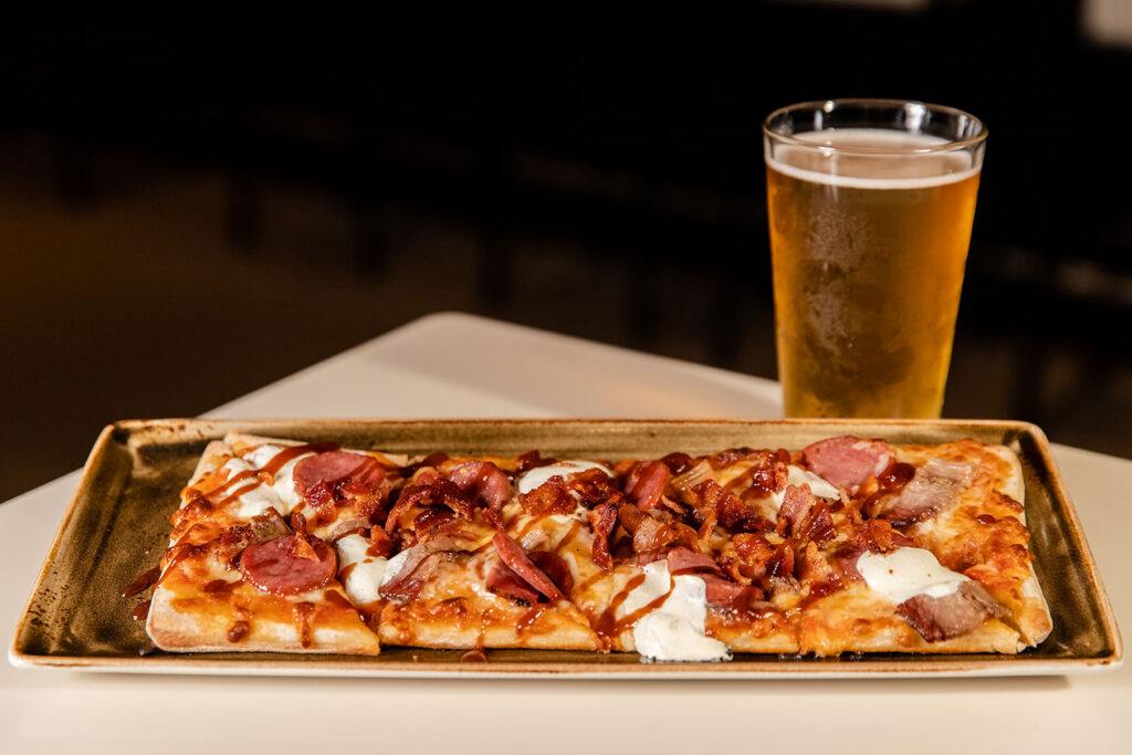 a pizza and a glass of beer on a table